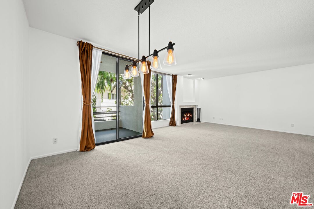 1312 South Saltair Avenue, Unit 215 Los Angeles, CA 90025 - Photo 9 of 31 a view of a room with a flat screen tv and refrigerator