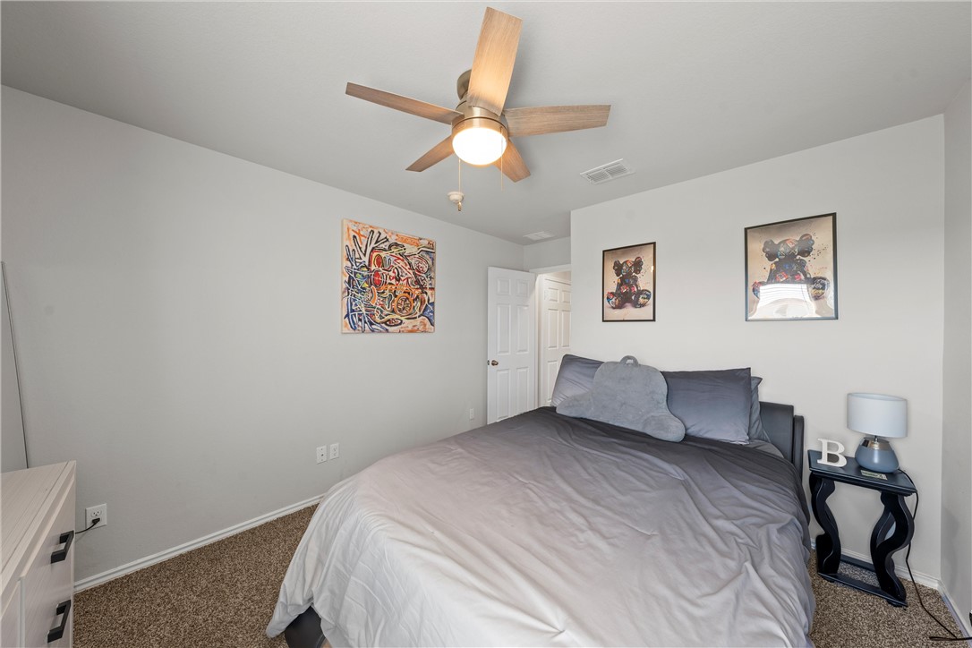 7009 Llano Drive China Spring, TX 76633 - Photo 13 of 25 a bedroom with a bed and a chandelier