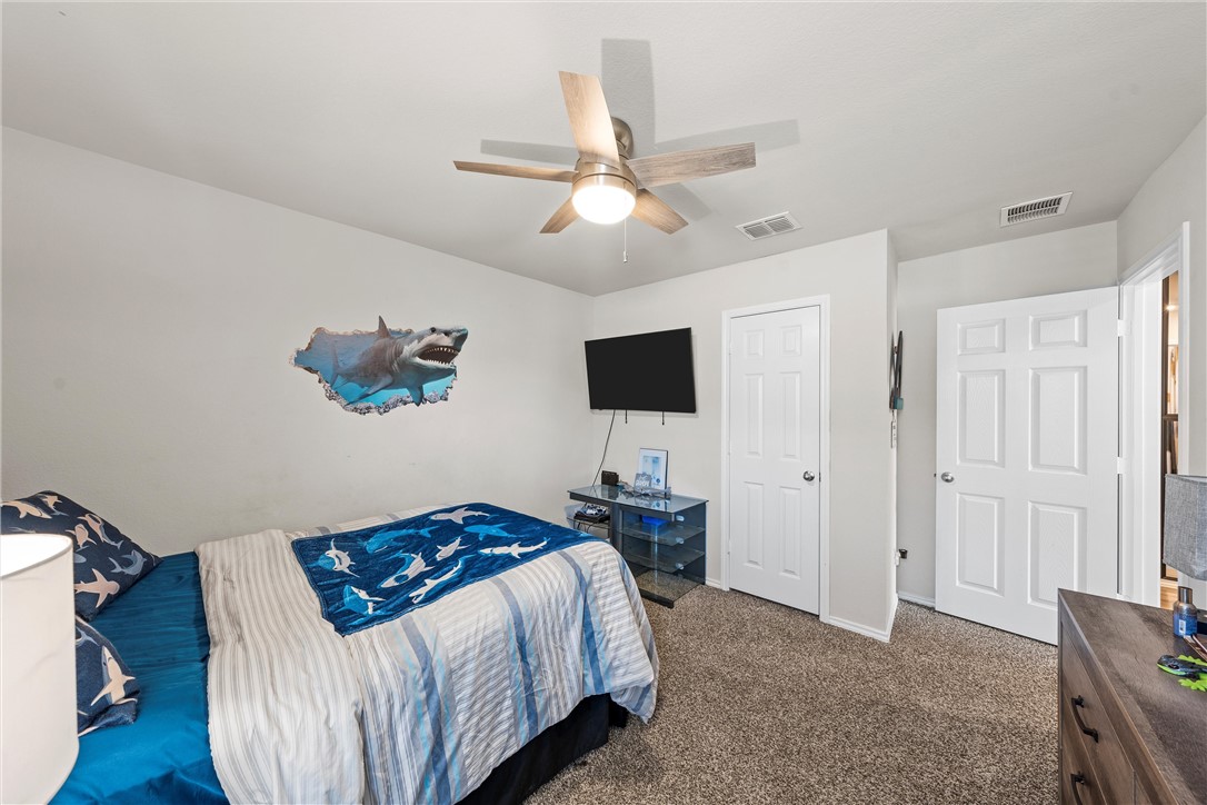 7009 Llano Drive China Spring, TX 76633 - Photo 18 of 25 a bedroom with a bed and a chandelier