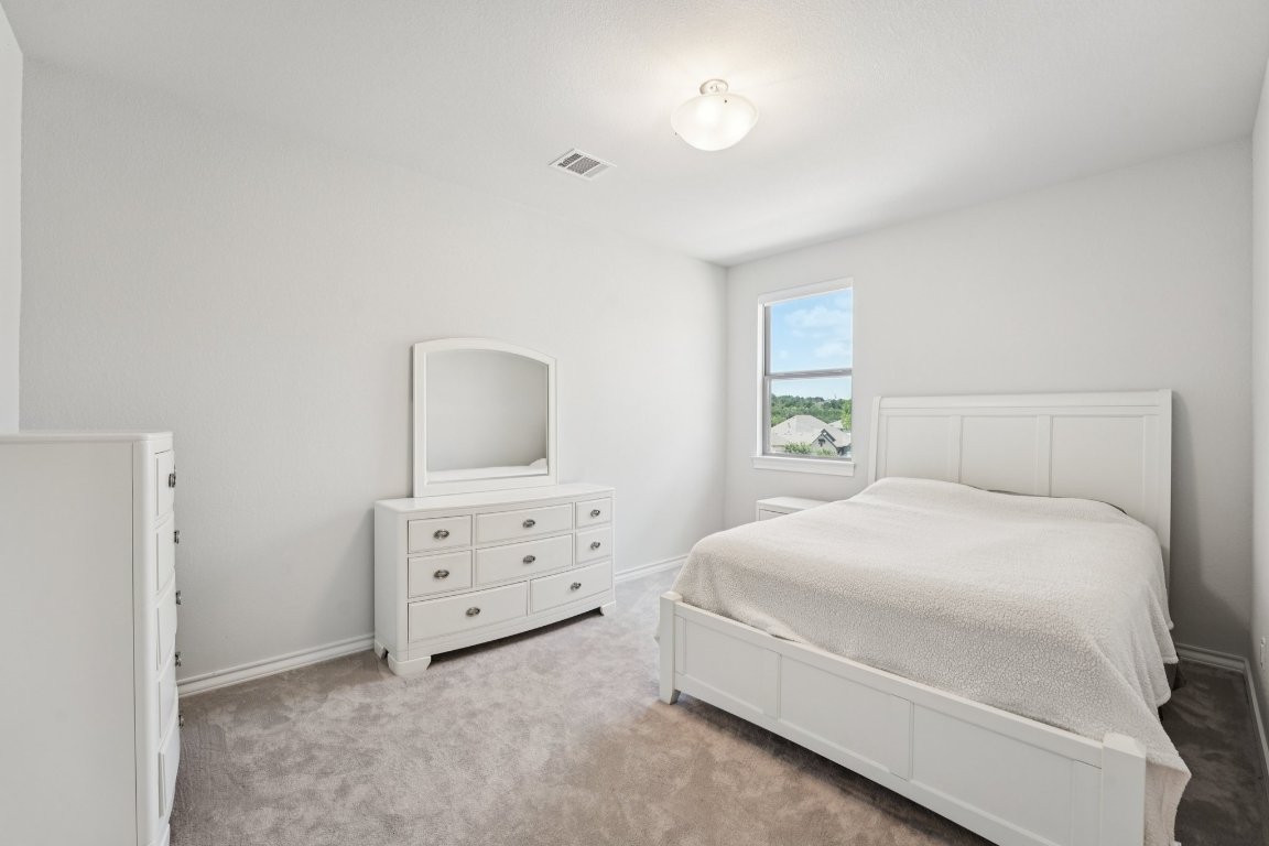 120 Hollytree Court Georgetown, TX 78628 - Photo 24 of 40 a bedroom with a bed and a dresser in it