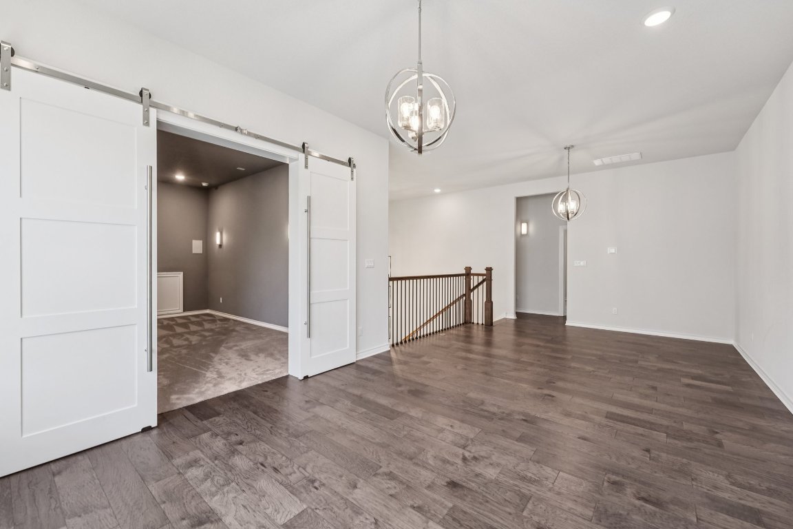 120 Hollytree Court Georgetown, TX 78628 - Photo 27 of 40 a view of an empty room with wooden floor and a large mirror