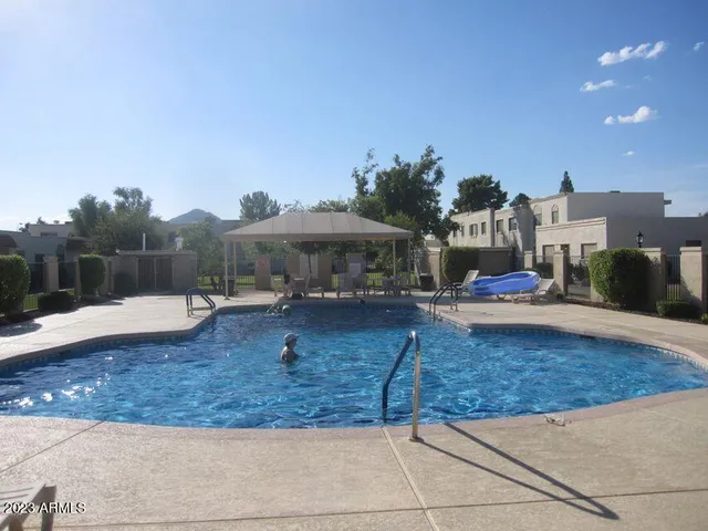 a view of a house with pool and chairs