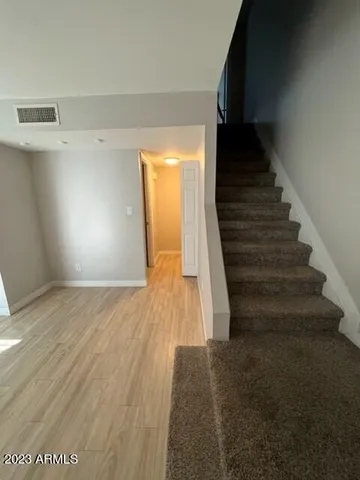 a view of a hallway with wooden floor and staircase