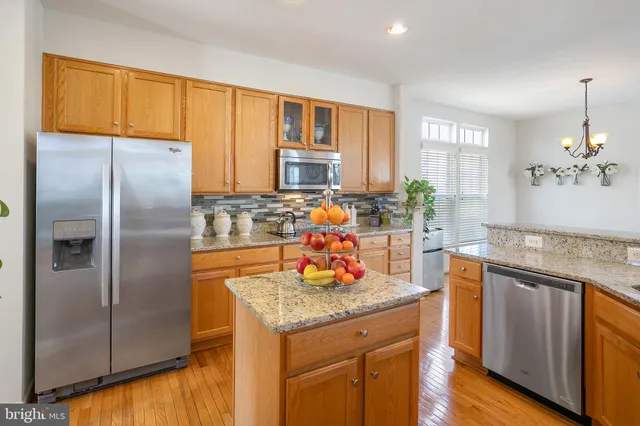 a kitchen with stainless steel appliances granite countertop a refrigerator a stove and a sink