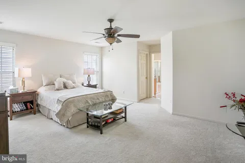 a spacious bedroom with a bed and a chandelier