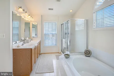 a bathroom with a tub sink and mirror