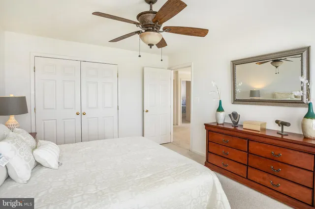 a bedroom with a large bed and a mirror on dresser