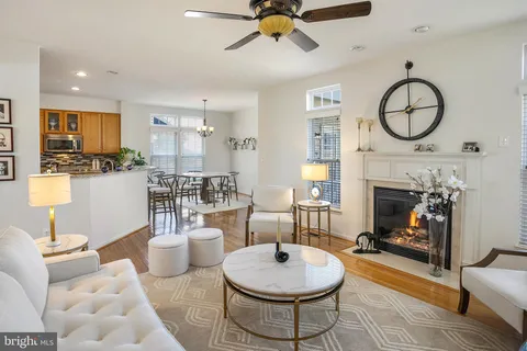 a living room with furniture a fireplace and a chandelier