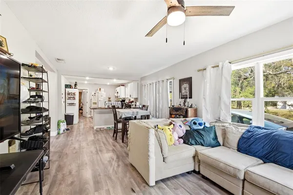 a living room with furniture a ceiling fan and a window