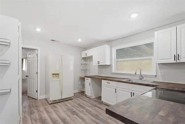 a kitchen with stainless steel appliances granite countertop a stove a sink and a refrigerator with wooden floors