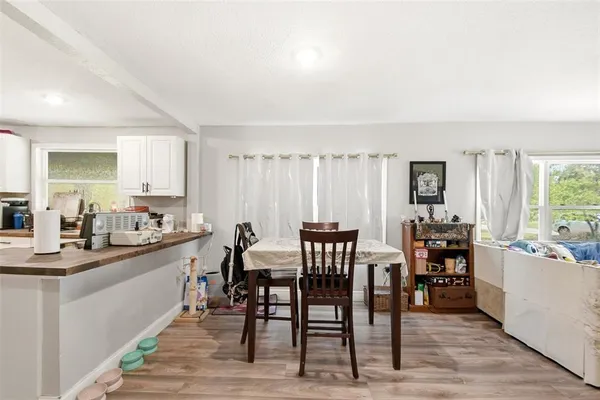 a kitchen with stainless steel appliances a dining table chairs and a white refrigerator