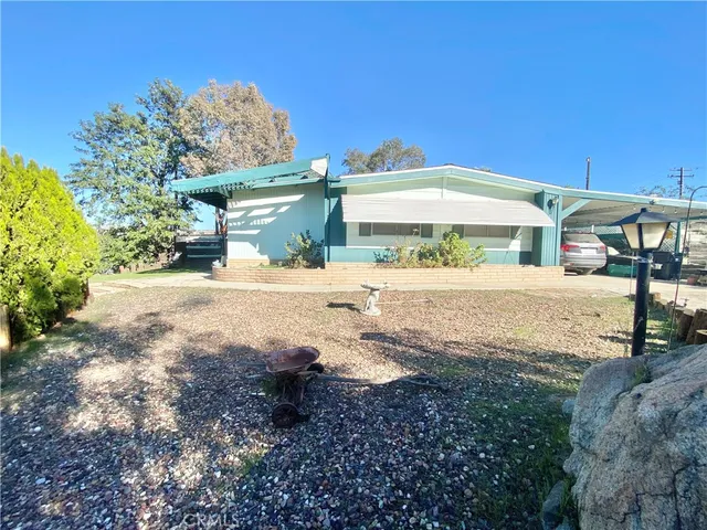 a view of a house with yard and sitting area
