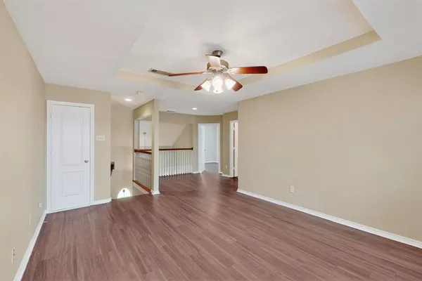 a view of a room with wooden floor and a ceiling fan