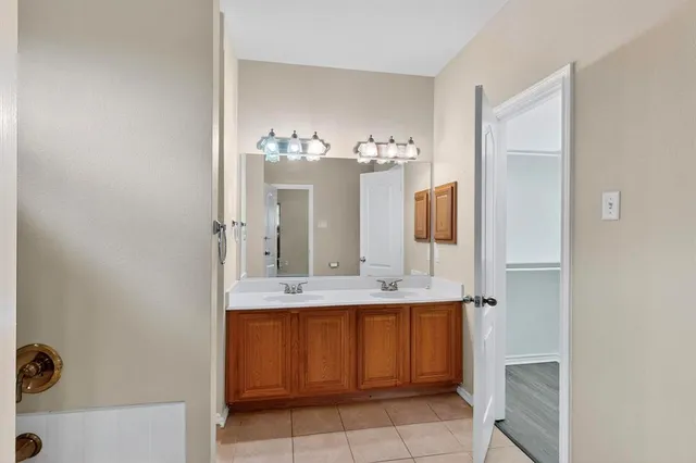 a bathroom with a granite countertop sink a mirror and shower