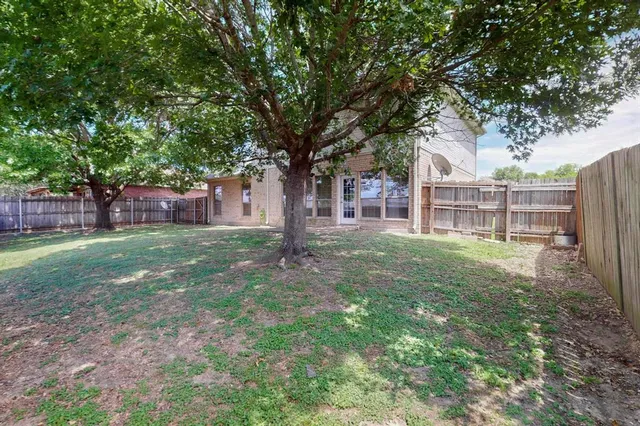 a view of a house with yard and a tree