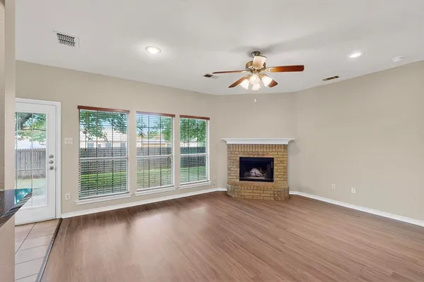a view of an empty room with a window and fireplace