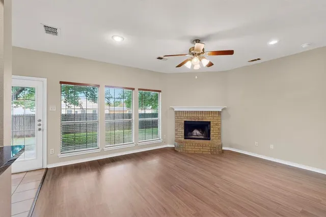 a view of an empty room with a window and fireplace