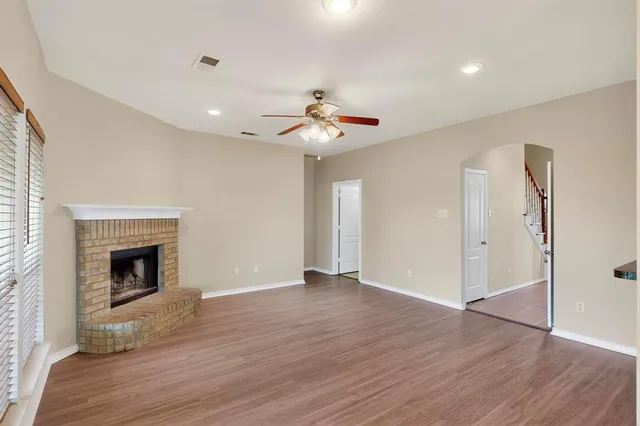 a view of an empty room window and wooden floor