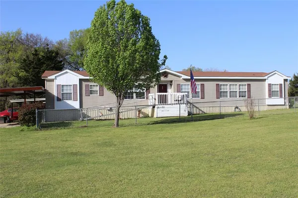 a front view of a house with a garden and yard