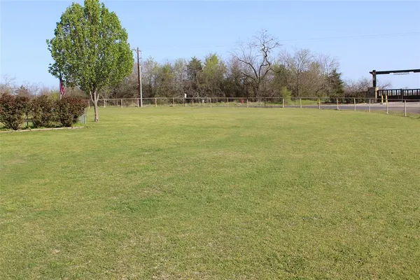 a view of a green field with trees in the background