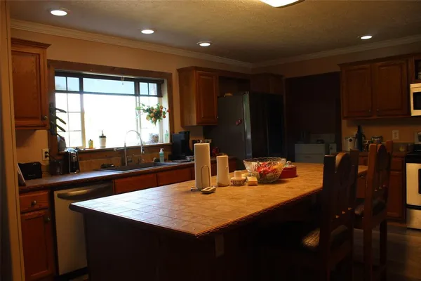 a kitchen with a sink a counter top space and living room view