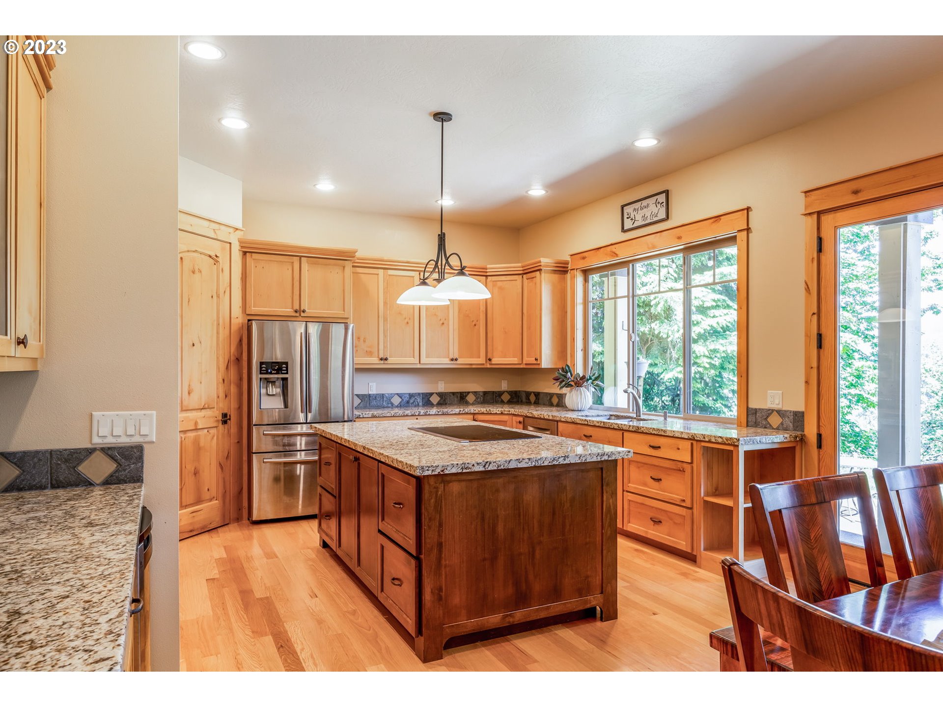 40091 Deerhorn Road Springfield, OR 97478 - Photo 16 of 46 a kitchen with stainless steel appliances granite countertop a stove a refrigerator a sink dishwasher and a dining table with wooden floor
