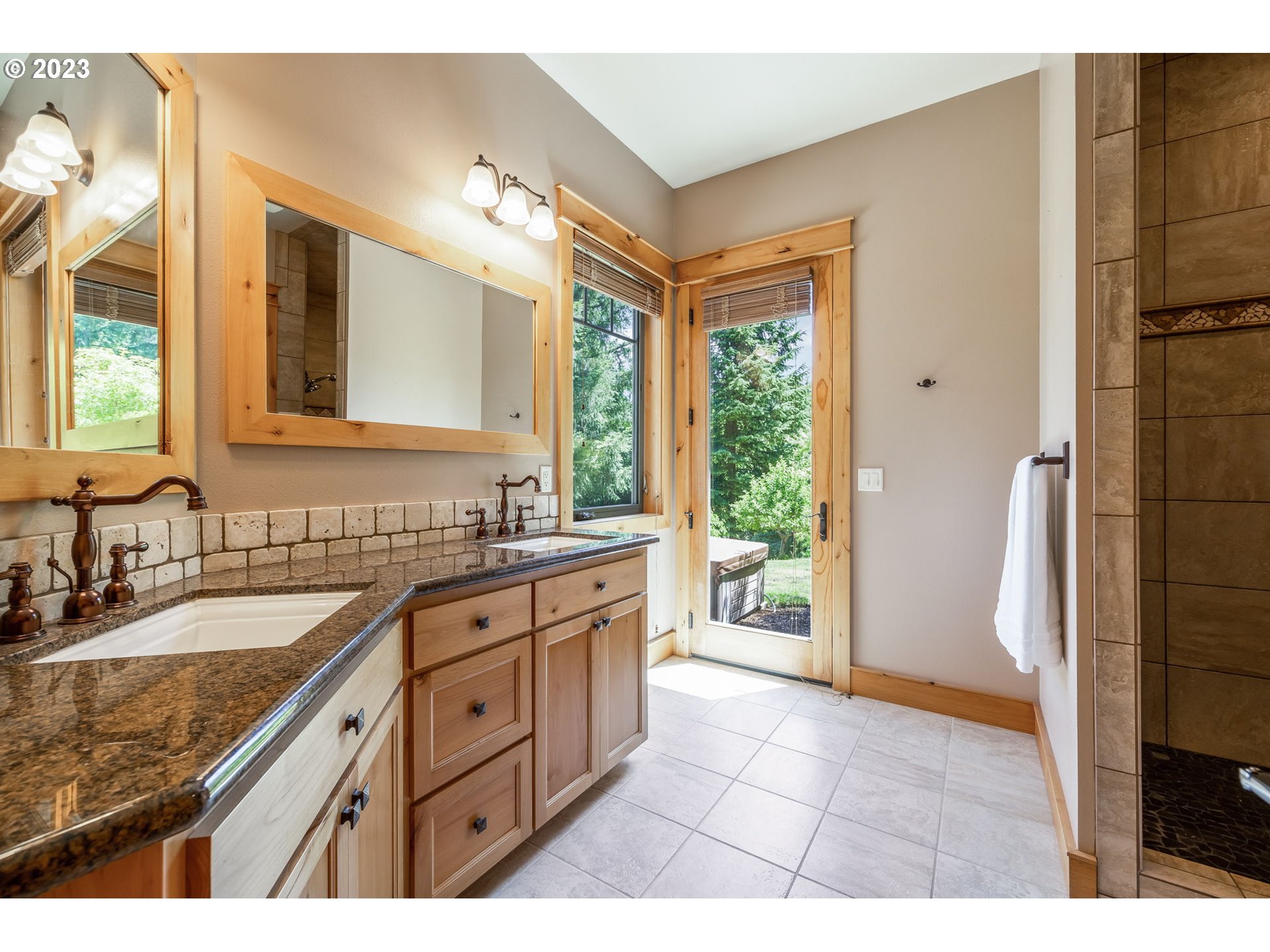 40091 Deerhorn Road Springfield, OR 97478 - Photo 28 of 46 a large bathroom with a granite countertop sink a large mirror a shower and a bathtub