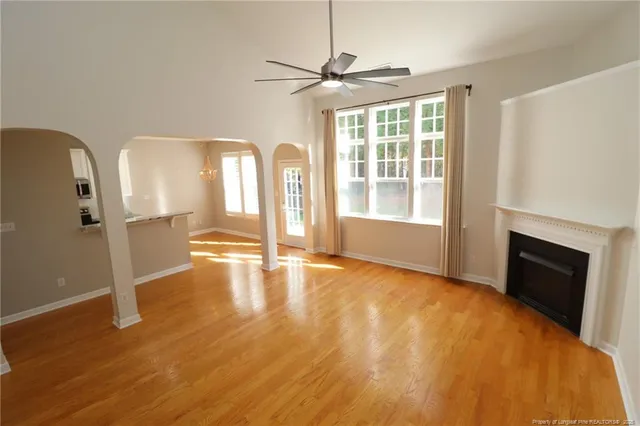a view of an empty room with a fireplace and a window