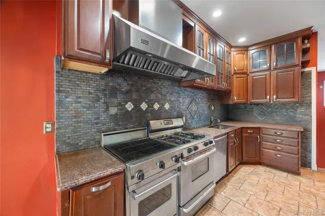 a kitchen with stainless steel appliances granite countertop a stove and a cabinets