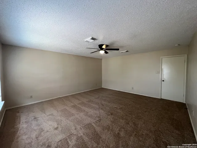 an empty room with a ceiling fan and hardwood floor