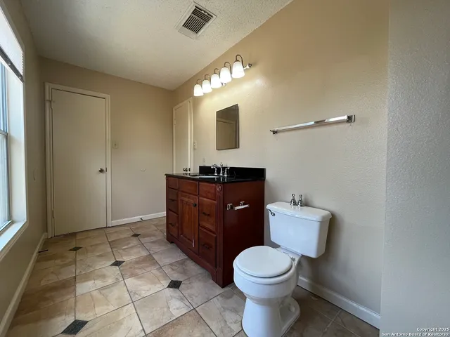 a bathroom with a toilet sink and mirror