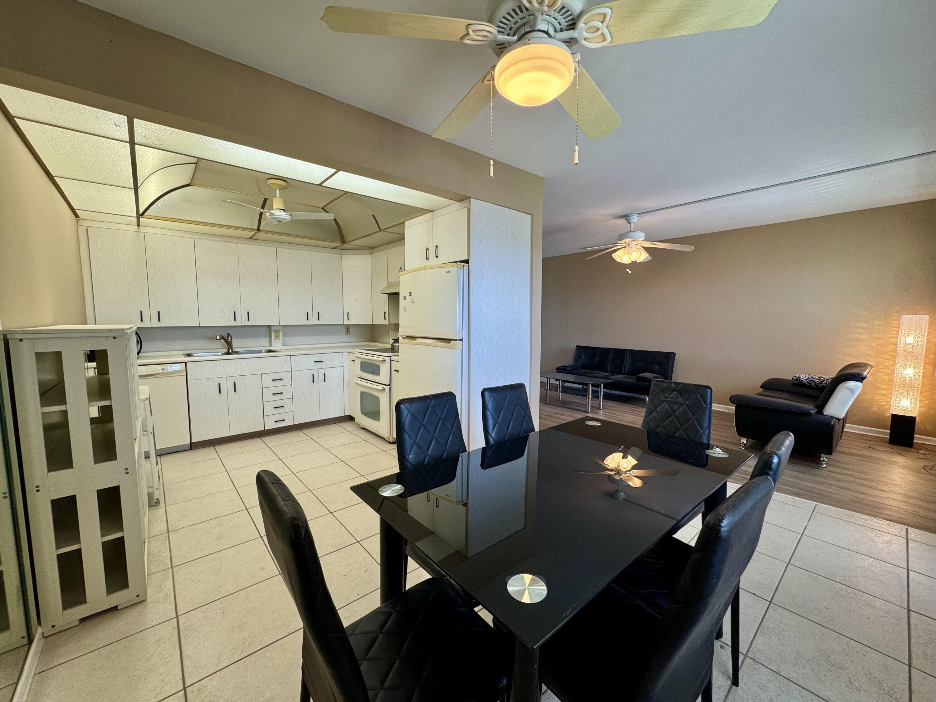 4019 Lincoln A Boca Raton, FL 33434 - Photo 7 of 36 a view of a dining room and livingroom with furniture wooden floor and a chandelier
