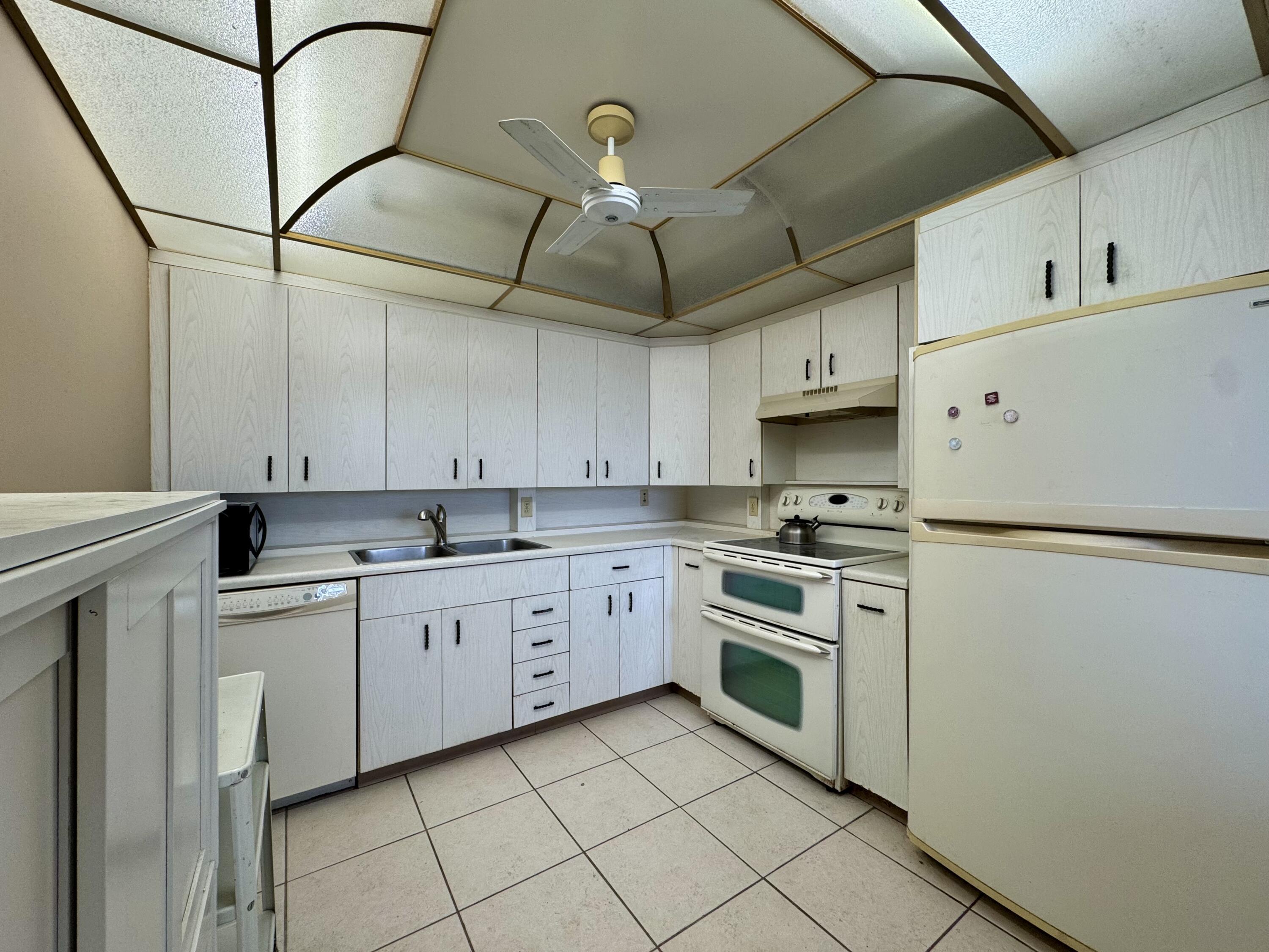 4019 Lincoln A Boca Raton, FL 33434 - Photo 9 of 36 a kitchen with cabinets and white stainless steel appliances