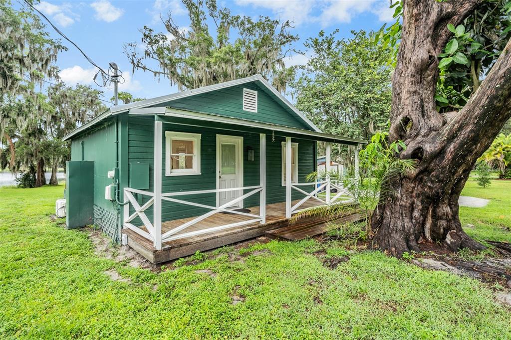a small house with a tree in the grass
