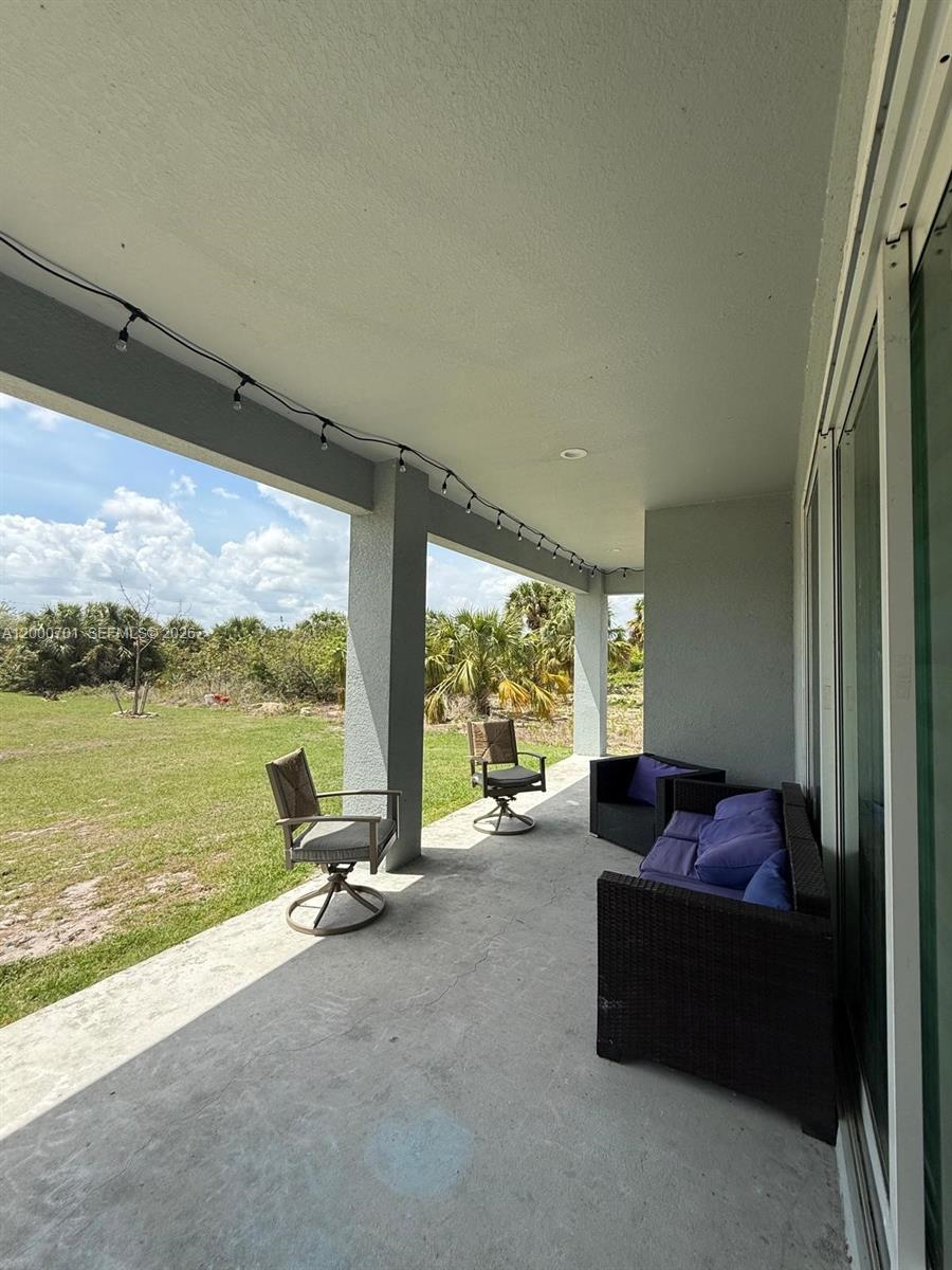 368 Neighborly Road LaBelle, FL 33935 - Photo 14 of 23 a living room with furniture and a floor to ceiling window