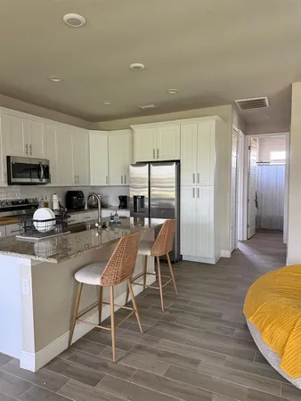 a kitchen with stainless steel appliances granite countertop a stove a sink a refrigerator and a microwave