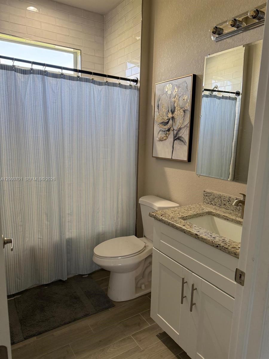 368 Neighborly Road LaBelle, FL 33935 - Photo 8 of 23 a bathroom with a granite countertop sink toilet and mirror