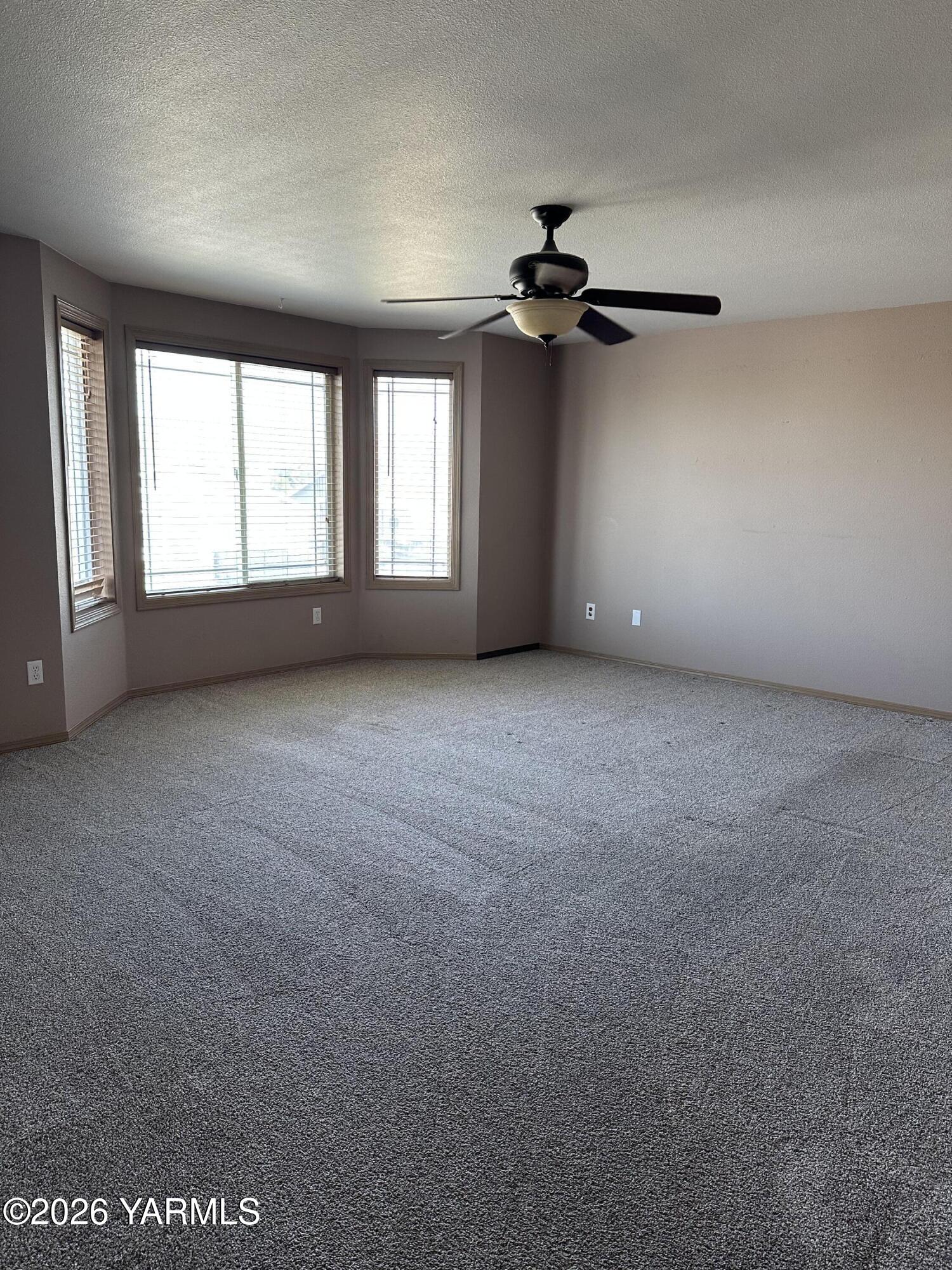 514 Cascade Avenue Moxee, WA 98936 - Photo 14 of 25 an empty room with windows and fan