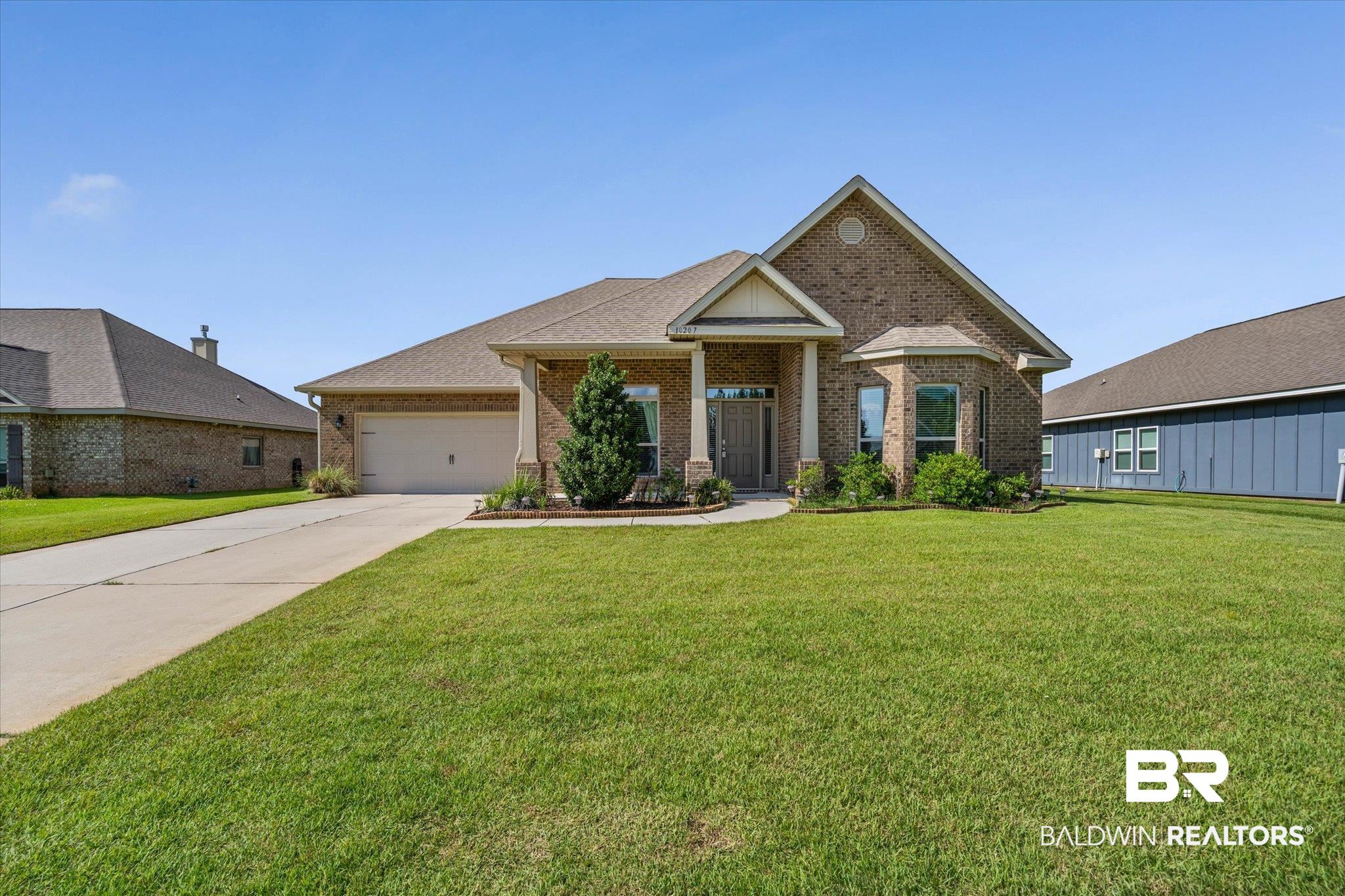 10207 Dunleith Loop Daphne, AL 36526 - Photo 21 of 23 View of front facade featuring a front lawn, brick siding, concrete driveway, an attached garage, and a shingled roof