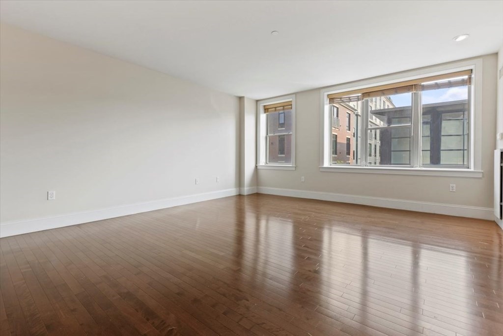 116 Rantoul Street, Unit 307 Beverly, MA 01915 - Photo 8 of 19 a view of an empty room with wooden floor and a window
