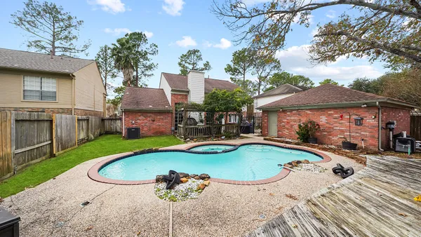 an aerial view of a house with swimming pool and furniture