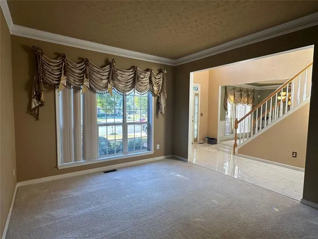 a view of an empty room with window and fire place