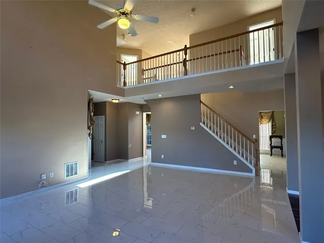 a kitchen with granite countertop a stove a kitchen island a sink dishwasher a dining table and chairs with wooden floor