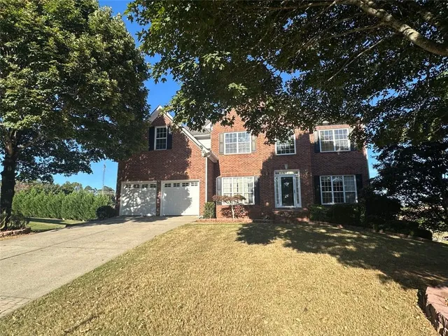 a front view of a house with a yard covered in snow