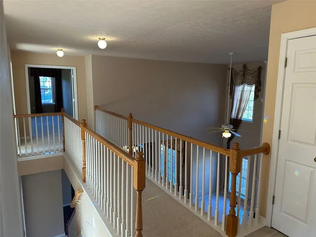 a view of staircase with lots of frames on wall and windows