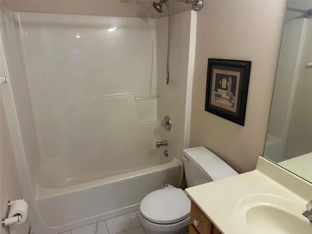 a bathroom with a granite countertop toilet and a sink