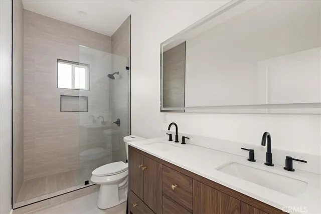 a bathroom with a toilet a sink a window and mirror