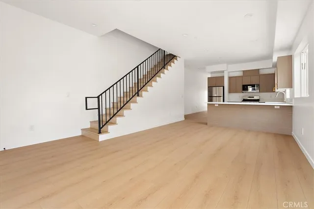 a kitchen with stainless steel appliances a sink a stove a refrigerator and cabinets