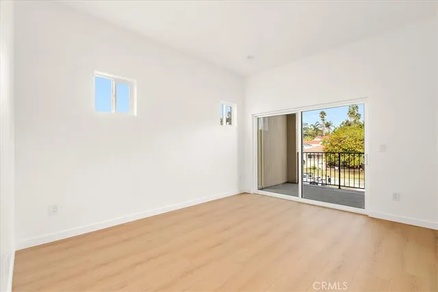 an empty room with sliding door and wooden floor