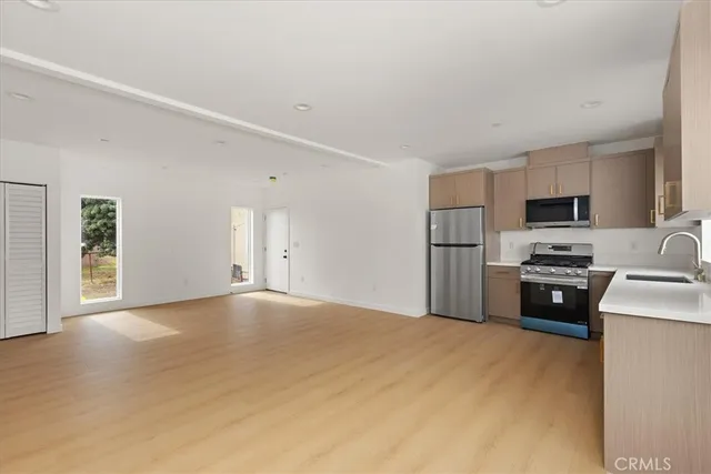 a view of a livingroom with wooden floor and a bathroom